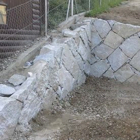 Steinmauer aus Granitblocksteinen mit kleinen Fugen teils händisch verlegt